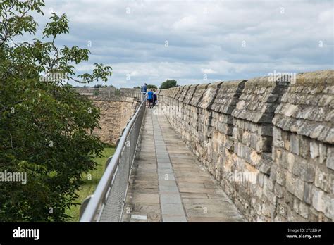 Visitors walking on part of the Medieval Wall Walk at Lincoln Castle ...