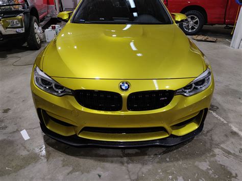 a yellow car parked in a garage next to other cars