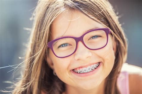 Happy smiling girl with dental braces and glasses. Young cute caucasian ...