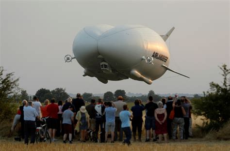 Cheering spectators gather to watch the 'Flying Bum' on its maiden voyage in Bedfordshire ...