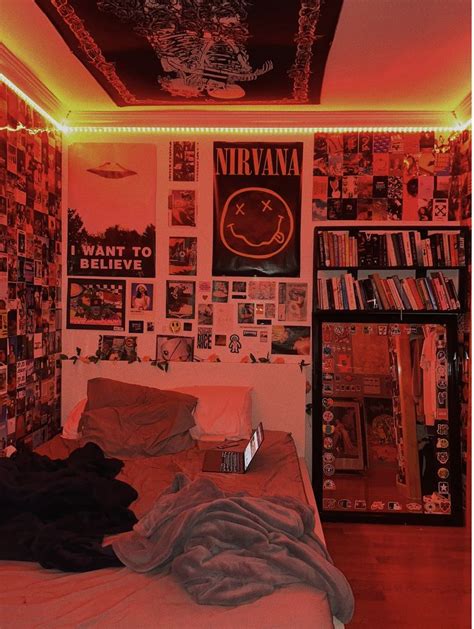 a bedroom with red lights and posters on the wall above the bed, along with bookshelves