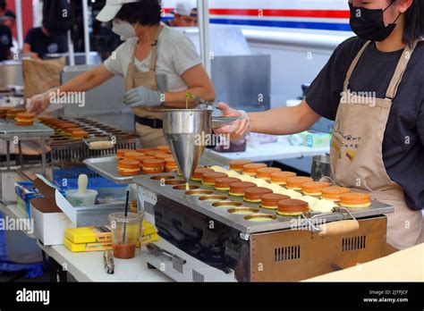 A person from Catmint Wheel Cake prepares different flavors of Taiwanese wheel cakes 車輪餅 or ...