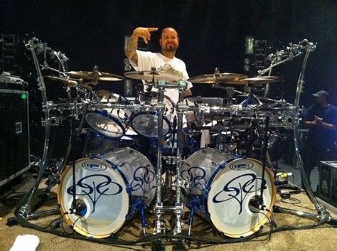 a man sitting behind a drum set on stage