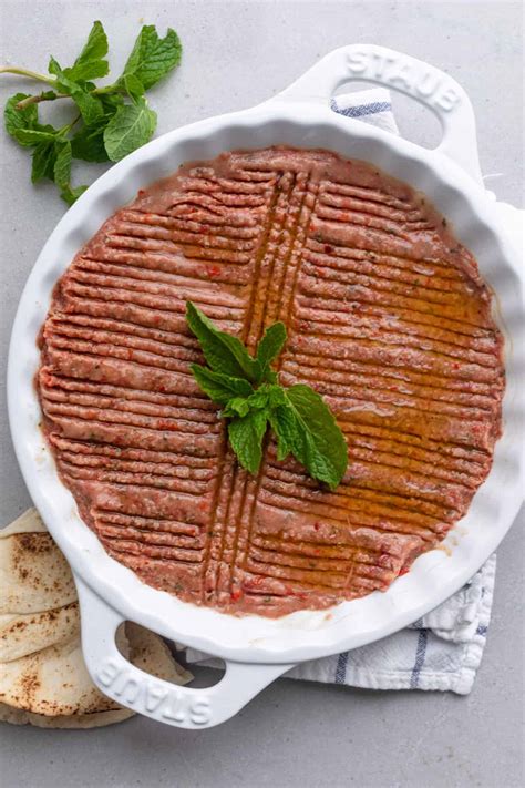 Round ceramic dish with Kebbeh Nayyeh pressed inside with decorative groves pressed into the raw ...