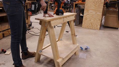 a person working on a piece of wood in a room full of workbench