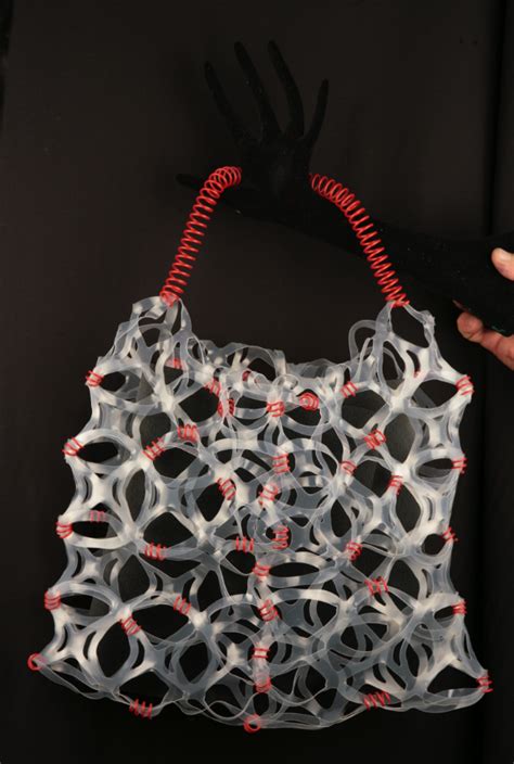 Tote bag made from plastic 6-pack rings. The handle is the spiral of a ...