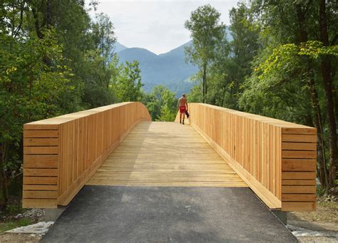 Architects create beautiful arched footbridge out of timber planks and shingles DANS Architects ...