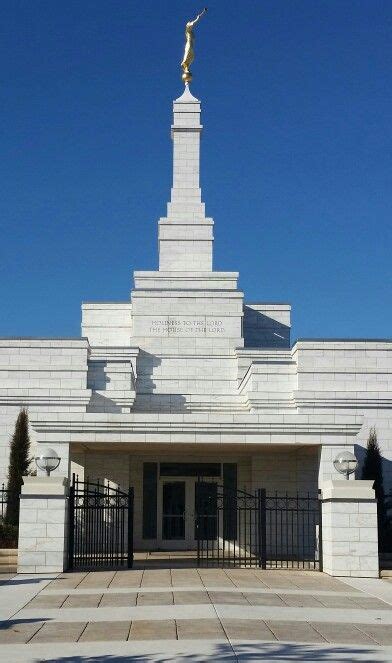 the front entrance of a large building with a statue on it's roof and gate