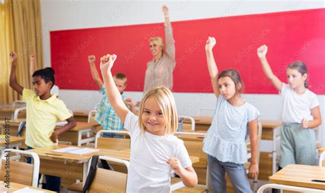 Teacher conducts gymnastics for elementary school children in the classroom Stock Photo | Adobe ...