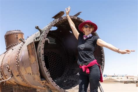 Premium Photo | Cheerful female tourist in a near an train graveyard in ...