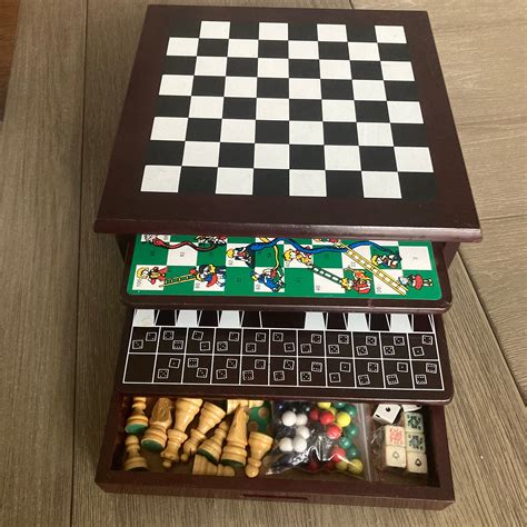 a wooden chess board and checker board in a box on the floor with other ...