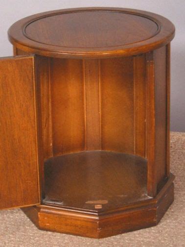 a wooden table with a round top on carpeted floor