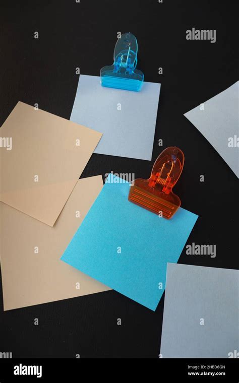 Post it notes with clips on dark background Stock Photo - Alamy