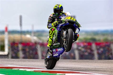 a man riding a motorcycle on top of a race track in front of a crowd