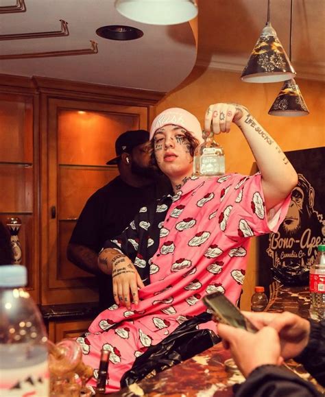 a woman in pink pajamas holding up a bottle with one hand and two other ...