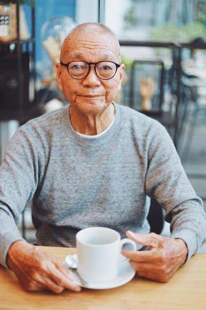 Premium Photo | Portrait of senior man with coffee on table sitting in cafe