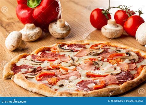 Top View of Delicious Capricciosa Pizza on Wooden Table. Ingredients Peeled Tomato, Cheese, Ham ...