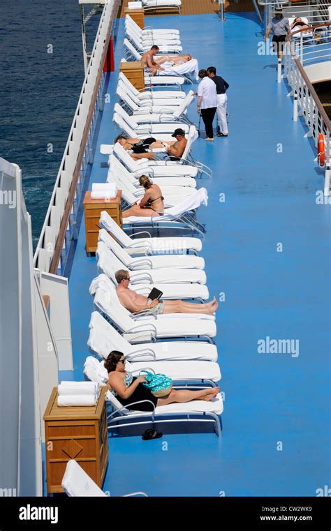 Passengers enjoy amenities on cruise ship sun pool tan relax Stock Photo - Alamy