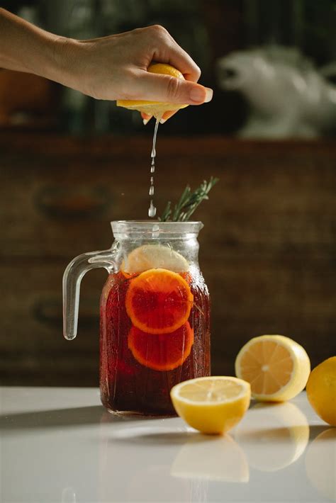 Crop woman squeezing lemon into drink · Free Stock Photo