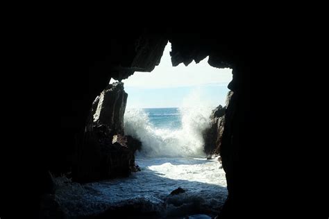 sea waves splashing at the entrance to a dark sea cave, sea cave entrance 4k HD Wallpaper