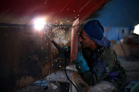 Man Holding Welding Rod and Welding Mask While Working · Free Stock Photo