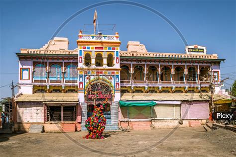 Image of Brightly colored , freshly painted goddess Ambadevi temple with worshiping tree in ...