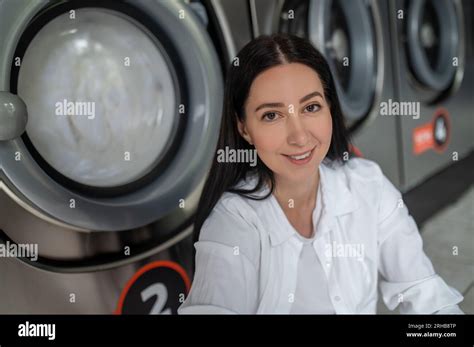 Woman waiting in public laundry room Stock Photo - Alamy