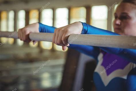 Female gymnast practicing gymnastics on the horizontal bar in the ...