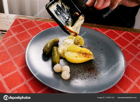 Swiss traditional dish called raclette including steamy potatoes ...