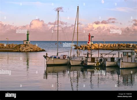 Cala Bona Port, fishing boats with reflections, cloudy sky and moon ...