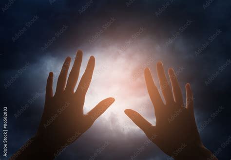 Hand reaching for the sky with dark stormy clouds Stock Photo | Adobe Stock