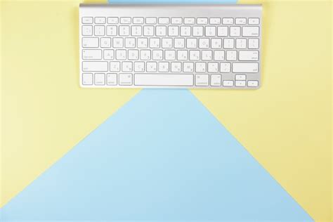 Free Photo | Wireless white keyboard on yellow and blue background