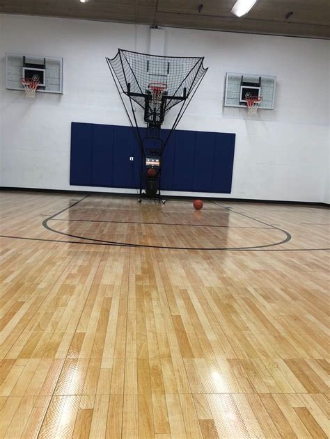 an indoor basketball court with wooden floors and hoop