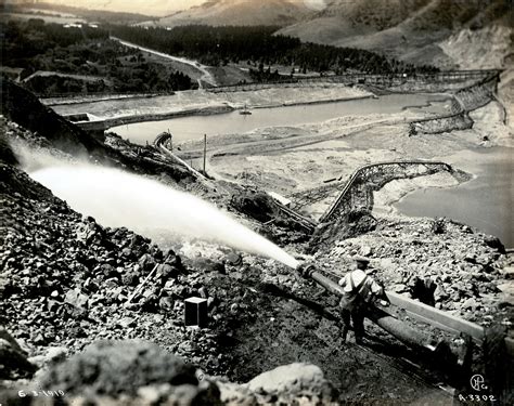 Miner using hydraulic hose to clear land while mining for gold | Picture This