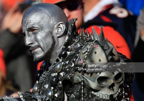 An Oakland Raiders fan wears silver paint and a spiked costume during... | Oakland raiders fans ...