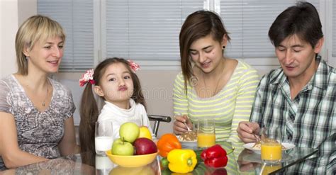 Family Sitting at Table Eating Meal Together Stock Photo - Image of parent, black: 57859222