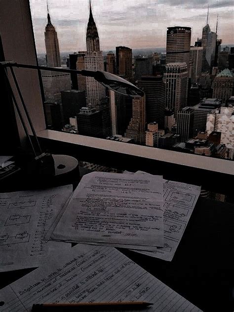 some papers are sitting on top of a desk in front of a window with a view of the city