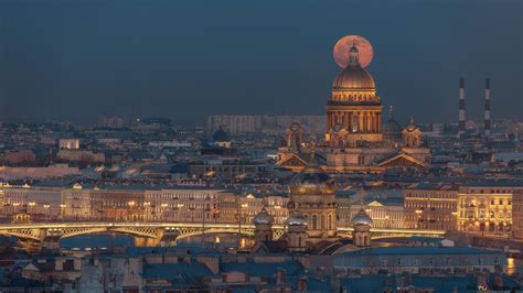 Full moon view behind building lights, bridge over water and ...