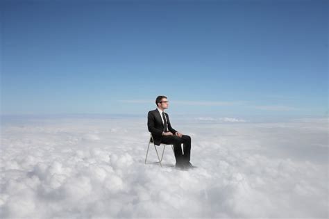 Premium Photo | Businessman sitting above the clouds