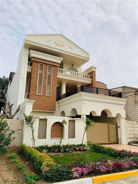 a house that is in the middle of some flowers and plants on the side of ...