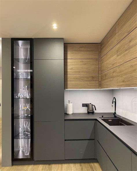 a modern kitchen with wooden cabinets and stainless steel counter tops, along with glass shelves