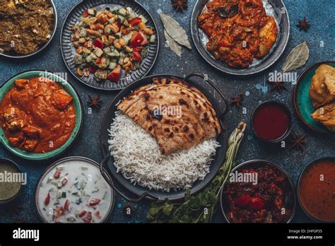 Assorted Indian ethnic food buffet on rustic concrete table from above ...