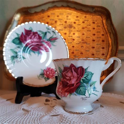 an antique tea cup and saucer with roses on them sitting on a lace tablecloth