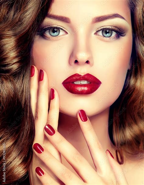 Beautiful model with curly hair and red manicure closeup . fashion ...