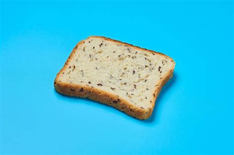 Single Square Piece Of Bread With Seeds For Toast Lies On Blue Table On Kitchen Stock Photo ...