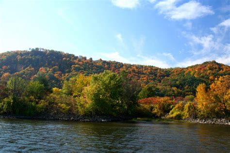 the river is surrounded by trees with colorful foliage on it's sides ...