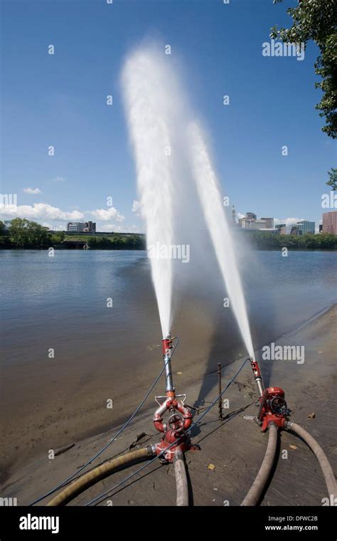 Hoses from a fire truck spraying water into a river Stock Photo - Alamy