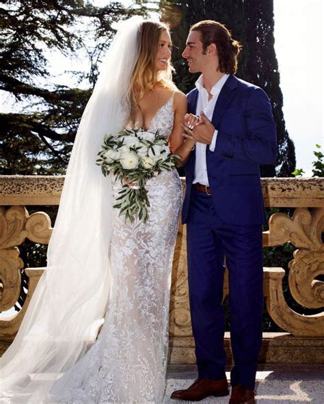 a bride and groom standing next to each other in front of an ornate balcony railing