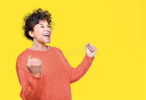 Happy Black Woman Celebrating Success with Clenched Fists on Yellow Background Stock Photo ...