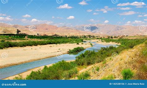 River in the Middle of the Desert of Iran with Mountains and Grass and the Horizont with Cloudy ...